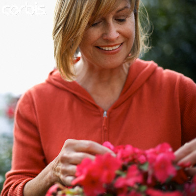 Woman Tending to Flowers --- Image by © Tim Pannell/Corbis